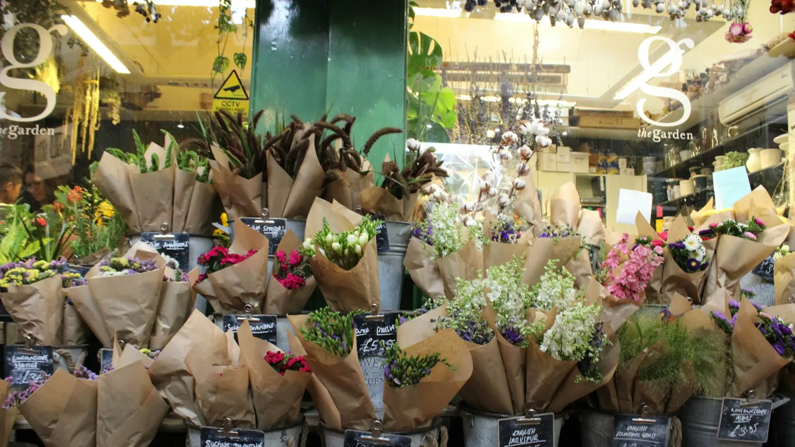 Bloemist met bossen bloemen in emmers
