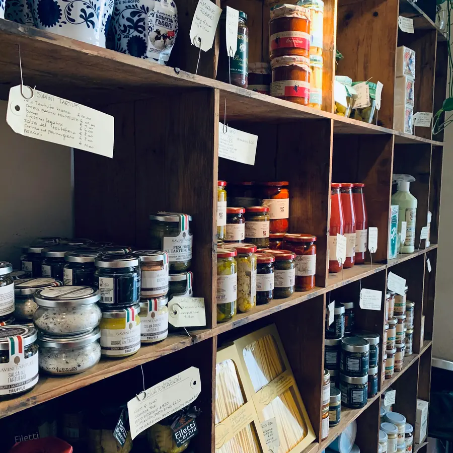 Houten schappen vol potten, blikken en flessen voorraad