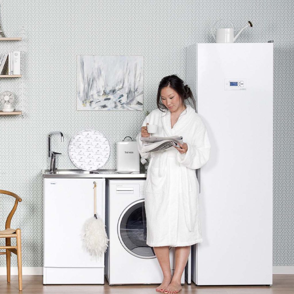 vrouw die een tijdschrift leest naast een scandinavische kleding droogkast