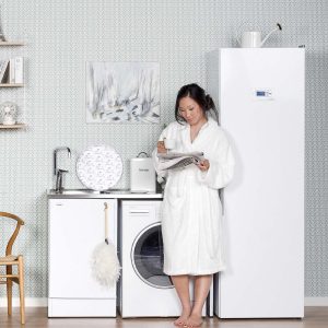 Frau liest eine Zeitschrift neben einem skandinavischen Wäschetrockner