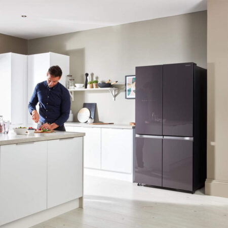 Person beim Kochen in der Küche mit dem Hitachi R-WB640VRU0 Amerikanischer Kühlschrank im Hintergrund.