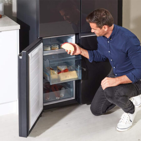 Persoon die de vrieslade van de Hitachi R-WB640VRU0 koelkast opent.